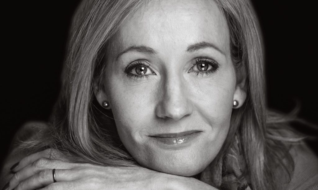 Black-and-white close-up portrait of J.K. Rowling resting her chin on her hands
